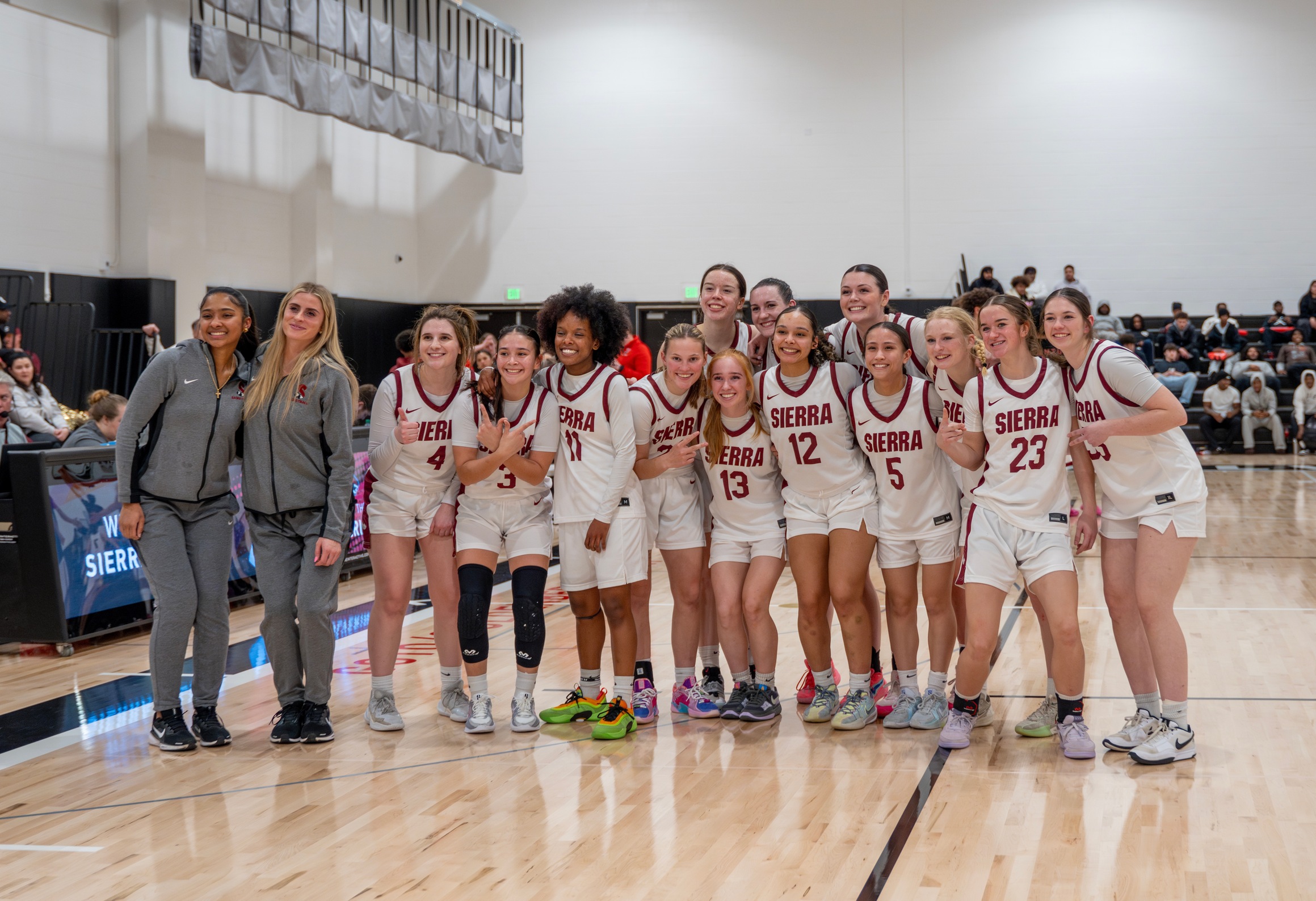 Women's basketball pose after first win in the new Sierra College gym.
