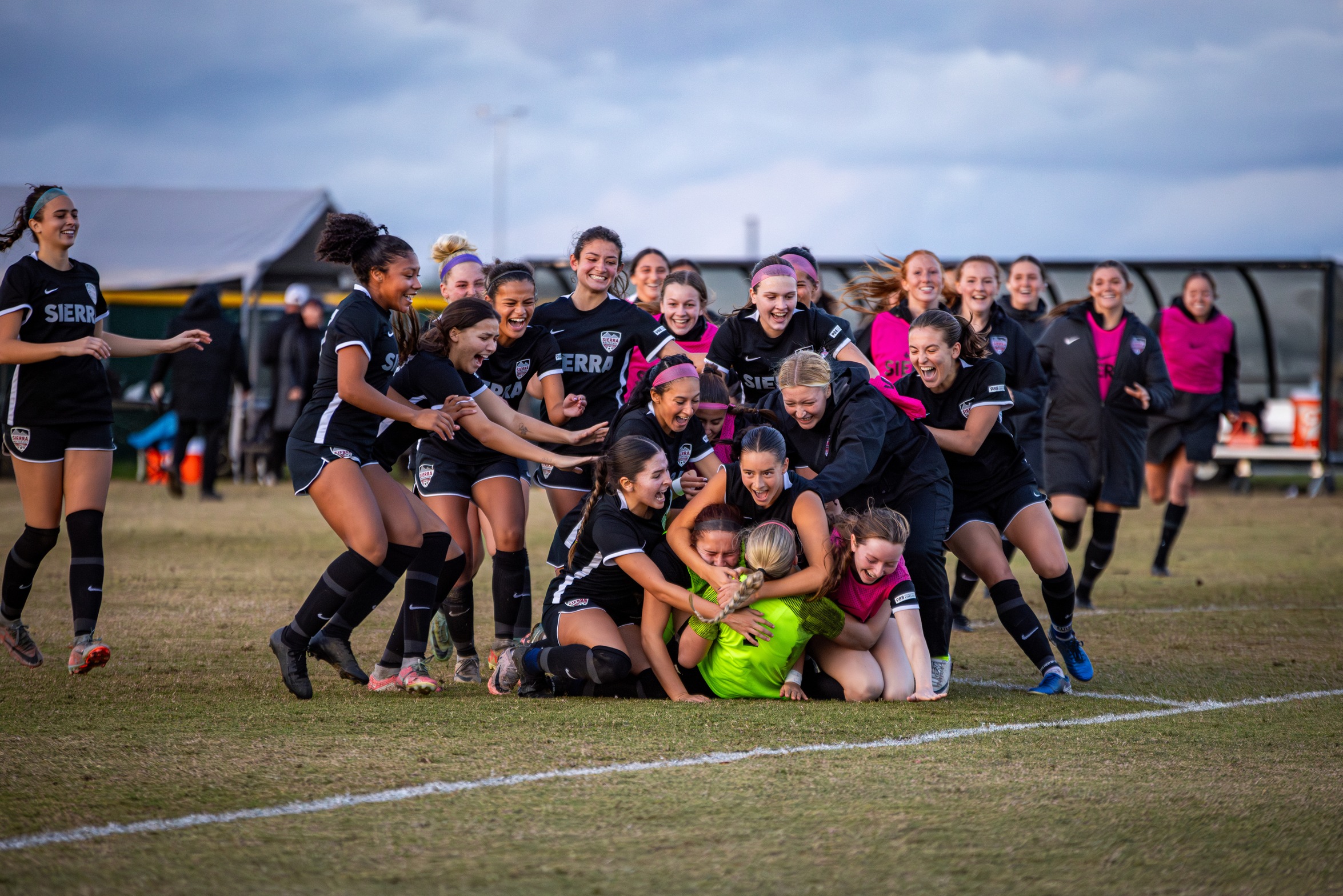 Sierra College Women's soccer runs to pile up on each other after winning against Santa Rosa in the play-offs.